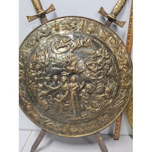 49 - Large brass wall hanging shield with crossed swords depicting mythical scene Circa 1930's along with... 