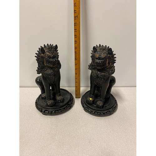 320 - Pair of large ceramic Chinese Foo Lions on wooden stands. 31cm tall.