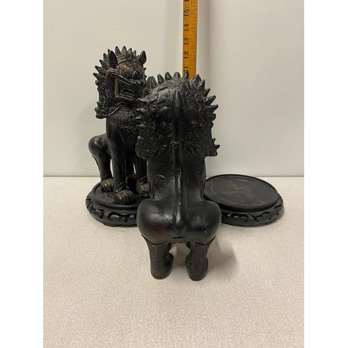 320 - Pair of large ceramic Chinese Foo Lions on wooden stands. 31cm tall.