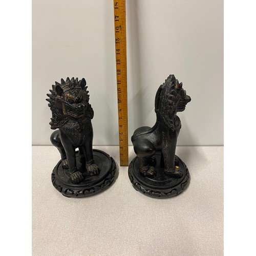 320 - Pair of large ceramic Chinese Foo Lions on wooden stands. 31cm tall.