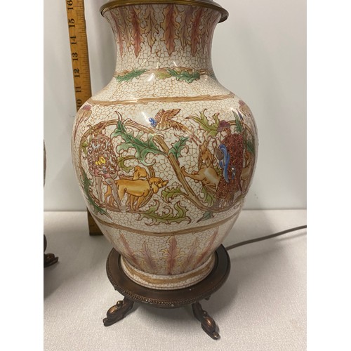 250a - Pair of vintage ceramic lamps depicting hunting scene on brass dolphin feet.