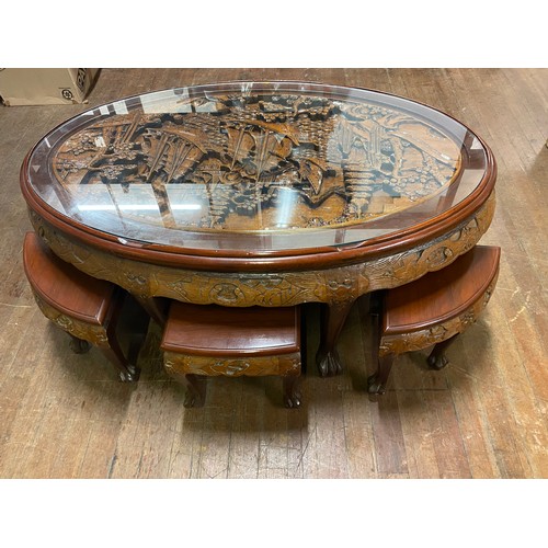 5 - Asian highly carved, glass topped coffee table with 6 stools. 121cm x 76cm x 53cm.