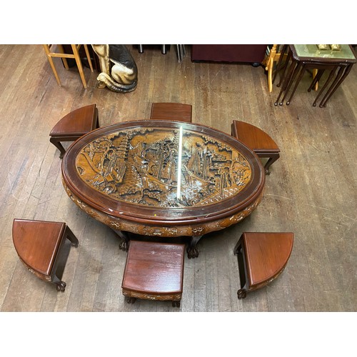 5 - Asian highly carved, glass topped coffee table with 6 stools. 121cm x 76cm x 53cm.