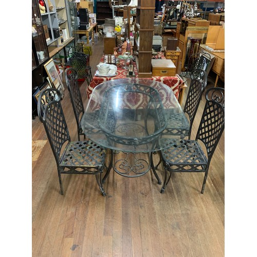 114 - Large metal garden table with glass top 153cm long and trestle design along with 4 matching chairs.