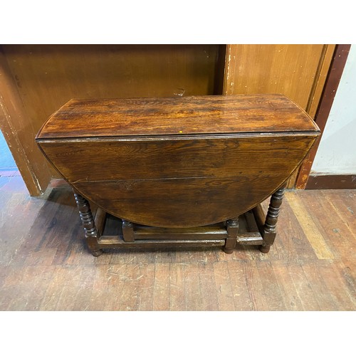 112 - Antique solid wood drop-leaf table on turned legs.