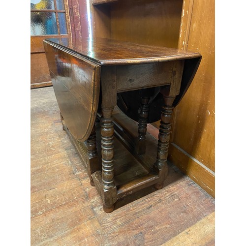 112 - Antique solid wood drop-leaf table on turned legs.