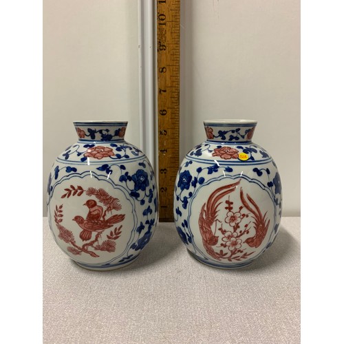 73 - Pair of Oriental blue and white vases with red bird design.