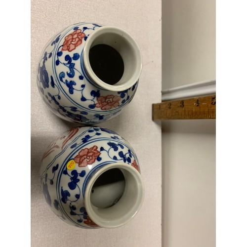 73 - Pair of Oriental blue and white vases with red bird design.