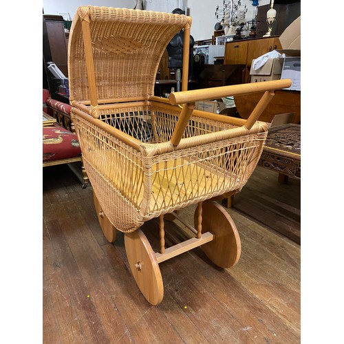 25 - Wicker dolls pram/moses basket with solid wood wheels. 95cm x 117 high