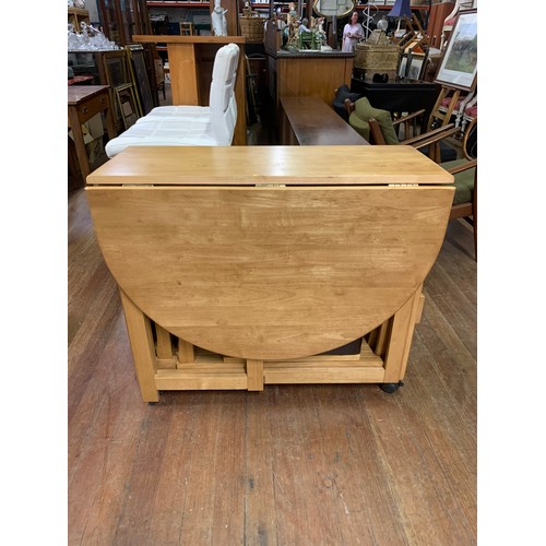 227 - Oak butterfly table and 4 matching fold away chairs with brown leather seats.