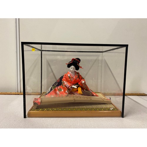 40 - Japanese Geisha figurine playing the Koto in display box.
33cm l x 24cm d x 25cm h