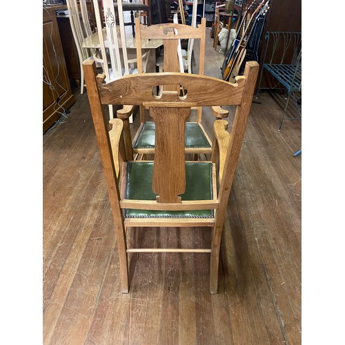 8 - Pair of Oak Arts and Crafts arm chairs with green leather seats.