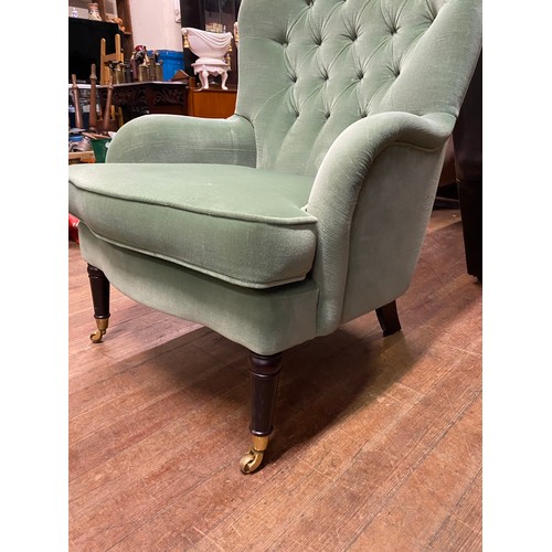 59 - Vintage upholstered button-back wingback chair on wooden legs with casters.