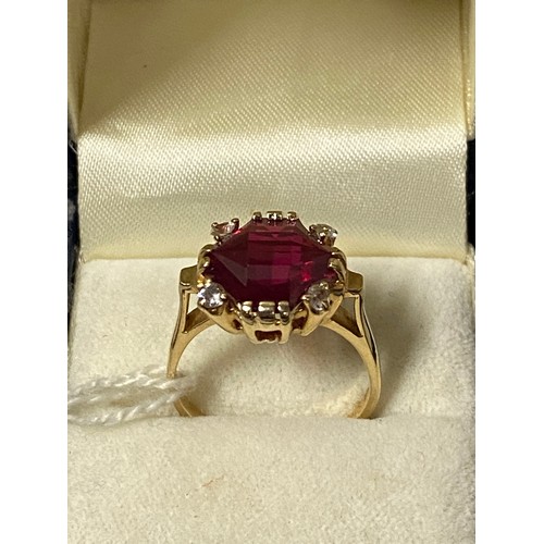 153 - 14ct gold dress ring set with large cut ruby and 4 white spined stones. Ruby 6x12x12mm. 5.78g