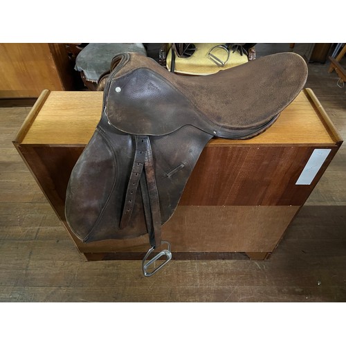 352 - Leather saddle with stirrups.