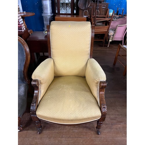 189 - Victorian arm chair on casters with yellow upholstery.