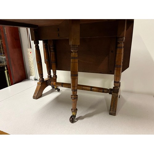 284 - Vintage drop-leaf table with turned legs on casters.