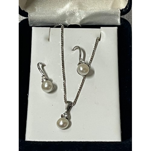 332 - Silver and pearl chain pendant and earing set.