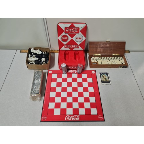 628 - New Coca Cola checkers game, chess set , dominoes and deck of comical cards.