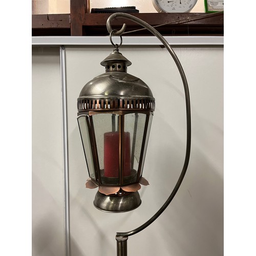 69 - Pair of graduated metal outdoor lantern stands with glass lanterns. Copper finish on curved foot sta... 