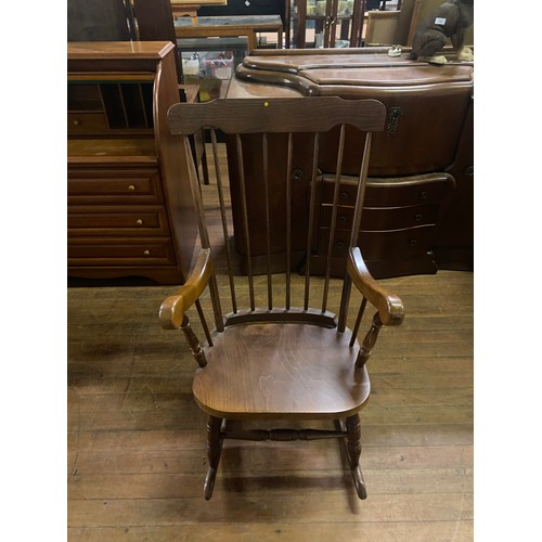 100 - Solid oak spindle back rocking chair.