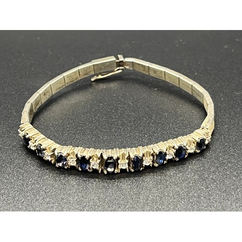 31 - Unmarked sapphire and white topaz tennis bracelet.