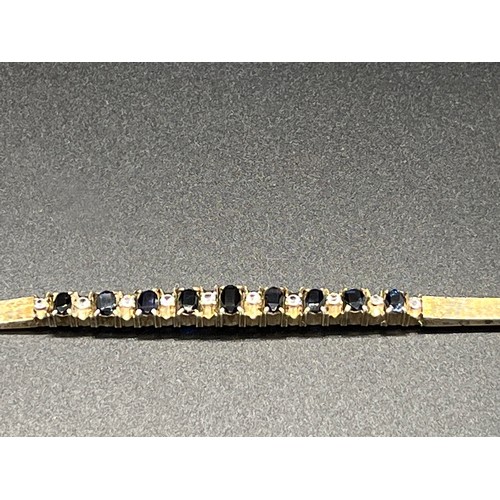 31 - Unmarked sapphire and white topaz tennis bracelet.