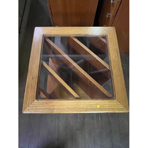 61 - Teak vinyl/magazine storage glass topped coffee table on casters.