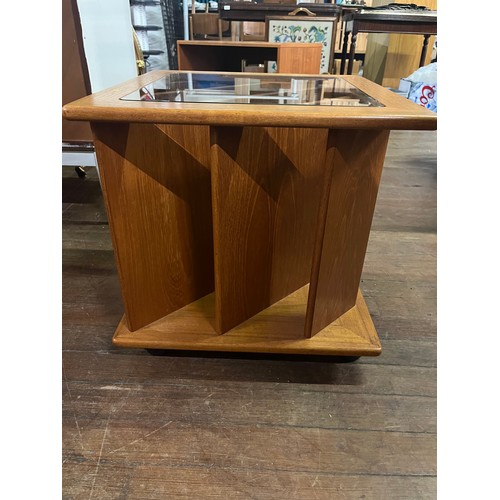 61 - Teak vinyl/magazine storage glass topped coffee table on casters.