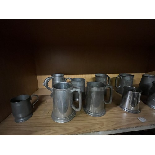 27 - 2 shelves of pewter tankards & brass wear