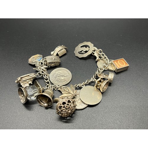 76 - Silver stamped charm bracelet with 18 silver charms to include Noahs ark & caravan etc. 
79g