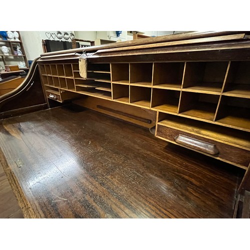 51 - Early 20th century light oak roll top desk, the tambour front opening to display compartments and wr... 