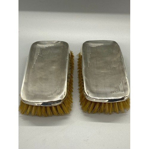 24 - Pair of Art Deco Hukin & Heath hallmarked silver clothes brushes.