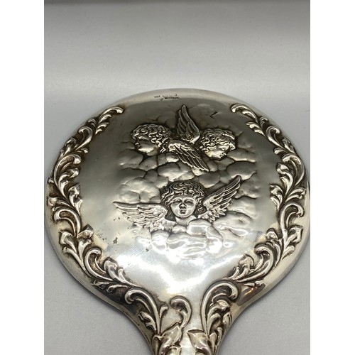 30 - Antique hallmarked silver hand mirror with cherub design.