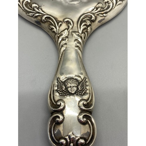 30 - Antique hallmarked silver hand mirror with cherub design.