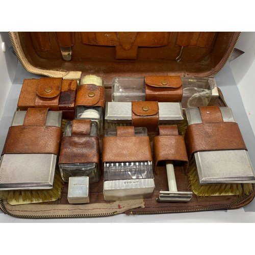 103 - Vintage silver fitted leather traveling vanity case with hallmarked silver lids and brushes by G.C. ... 