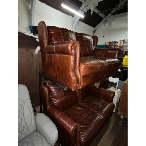 153 - 2 brown leather wingback sofas with stud detailing.