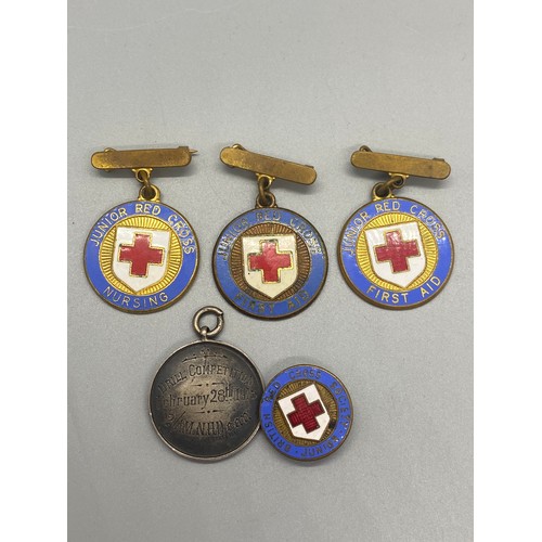 42 - 4 x red cross enamel badges along with silver royal air force drill competition medal dated 1918.