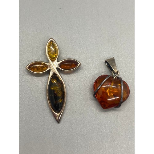 105 - Silver and amber cross pendant and chain along with 2 silver and amber pendants