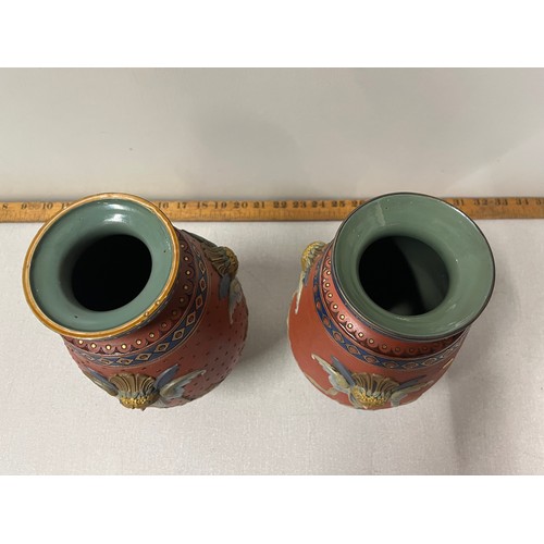 208 - 2 German Mettlach pottery tapered vases with raised mask head decoration on three scroll feet stampe... 