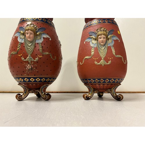 208 - 2 German Mettlach pottery tapered vases with raised mask head decoration on three scroll feet stampe... 