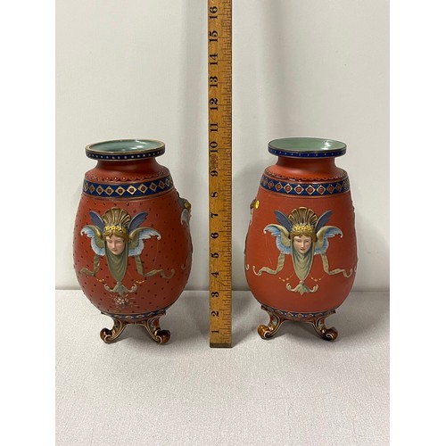 208 - 2 German Mettlach pottery tapered vases with raised mask head decoration on three scroll feet stampe... 