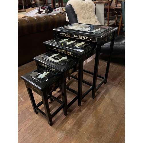 137 - a nest of black laquered oriental tables with mother of pearl inlay