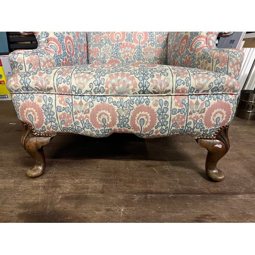 30 - Antique fireside arm chair, raised on short cabriole legs, with matching arm covers.