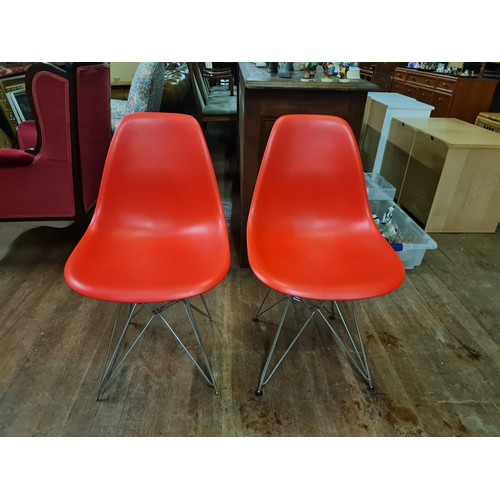 140 - 2 poppy red chairs in the style of Charles & Ray Eames.