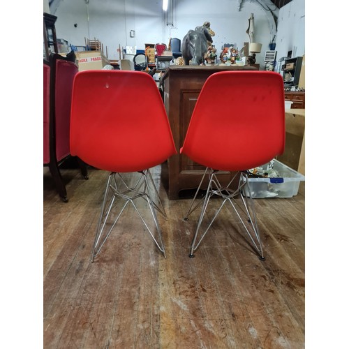 140 - 2 poppy red chairs in the style of Charles & Ray Eames.