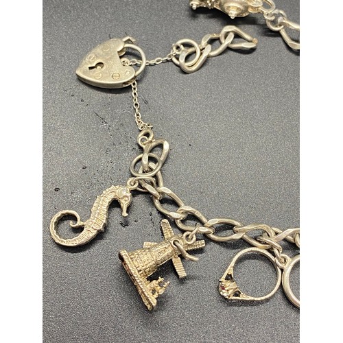 7 - Heavy silver charm bracelet with 12 charms and heart lock.