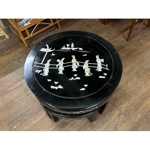 66 - a Chinese lacquered & mother of pearl tea table with 4 stools and glass top.