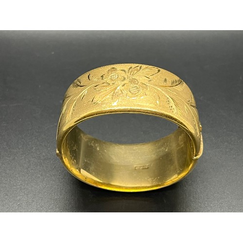 169 - 12ct rolled gold bangle with floral design.