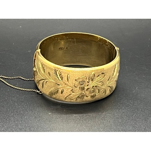 169 - 12ct rolled gold bangle with floral design.